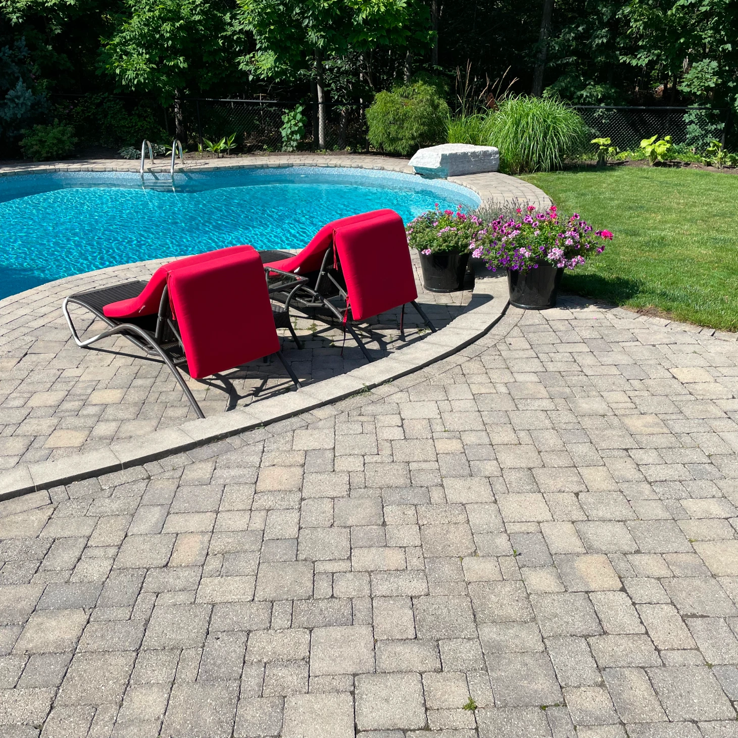 A backyard with a pool and chairs